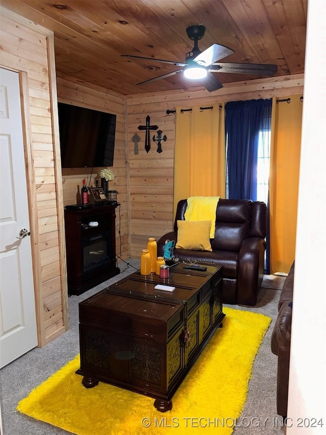 living room featuring carpet, wooden walls, ceiling fan, and wooden ceiling