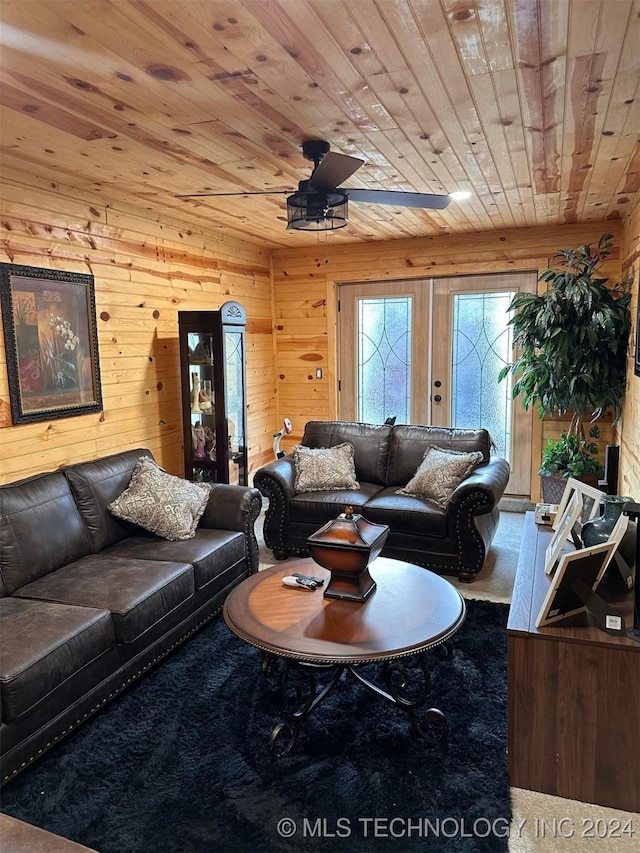 carpeted living room with french doors, ceiling fan, wooden walls, and wood ceiling