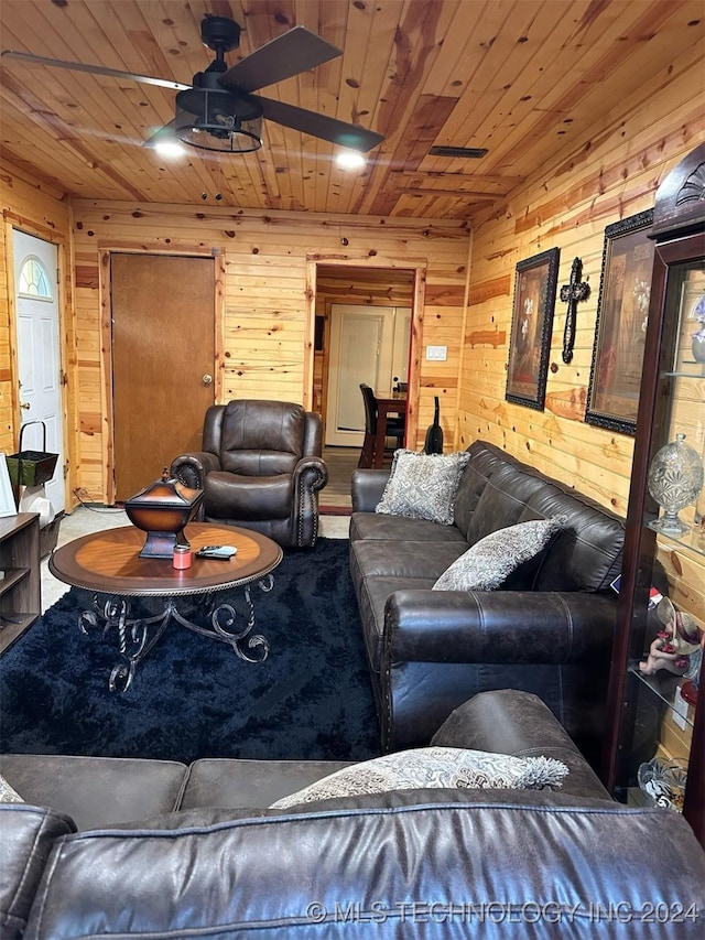 living room with ceiling fan, wooden walls, and wood ceiling