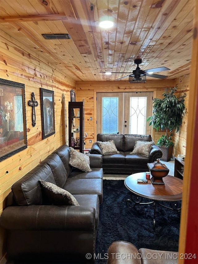 living room featuring french doors, wooden ceiling, and wood walls