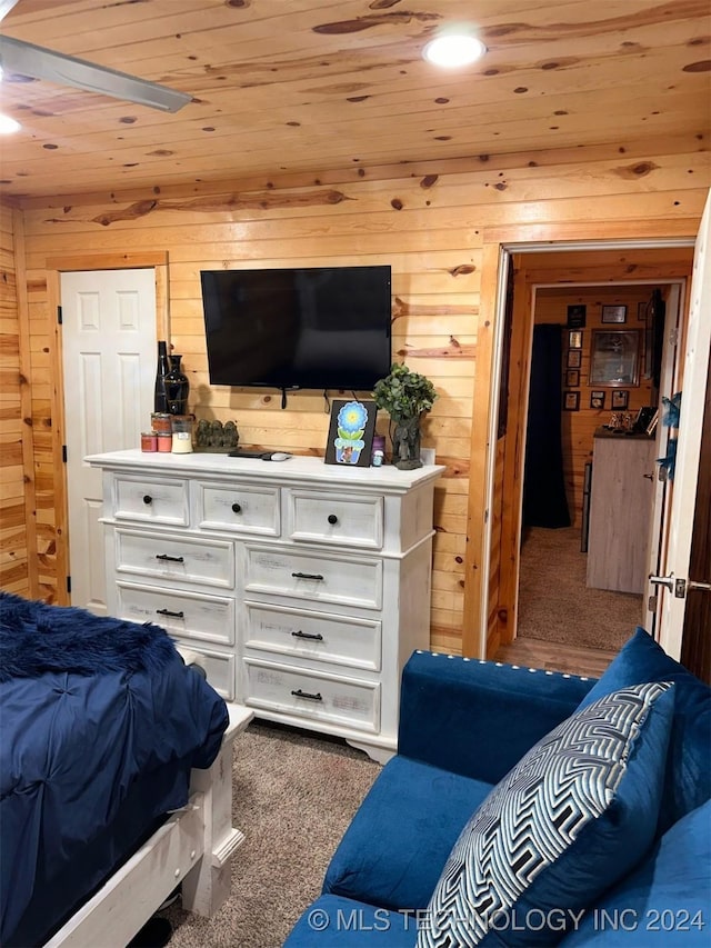 carpeted bedroom with wooden ceiling and wooden walls