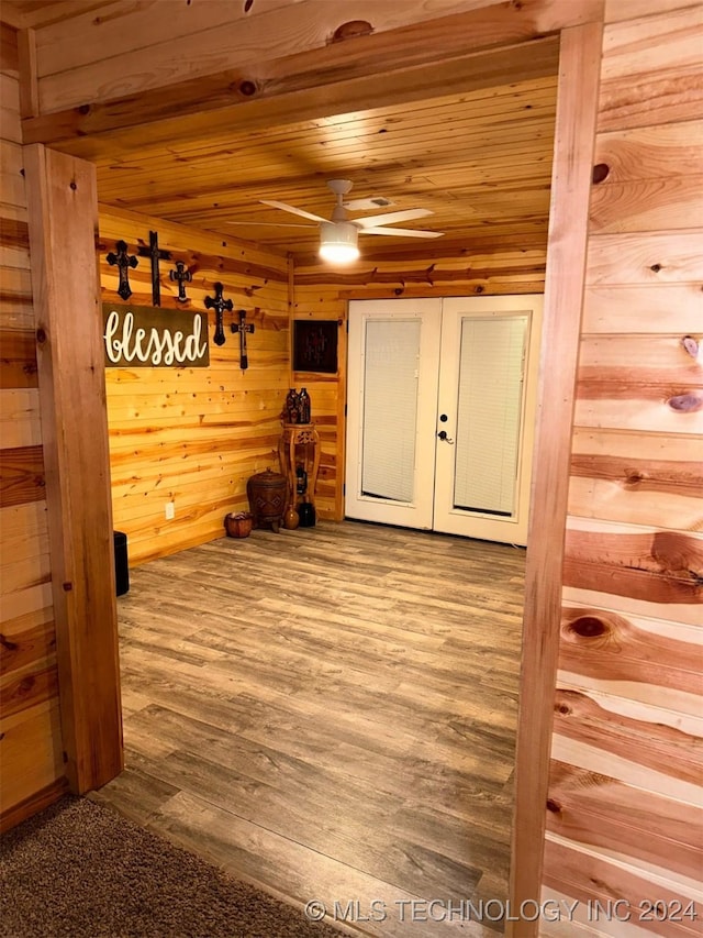 corridor with wooden walls, hardwood / wood-style floors, and wood ceiling