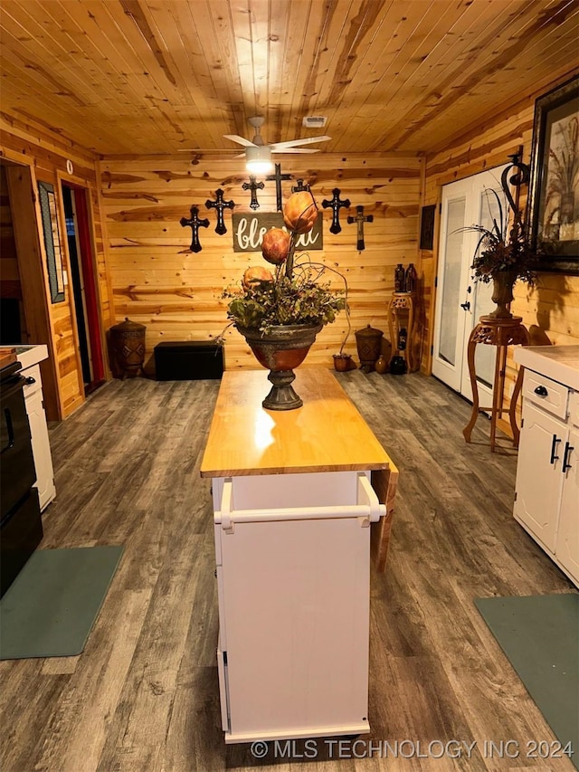 dining room with ceiling fan, dark wood-type flooring, and wooden ceiling