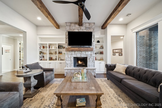 living room with ceiling fan, a fireplace, hardwood / wood-style flooring, beam ceiling, and built in features