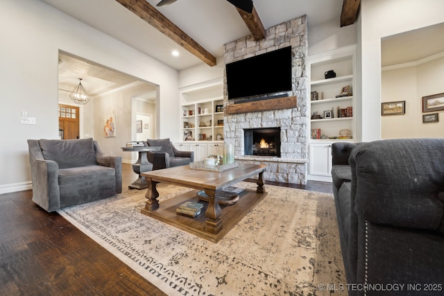 living room with a stone fireplace, a chandelier, beamed ceiling, dark hardwood / wood-style flooring, and built in features