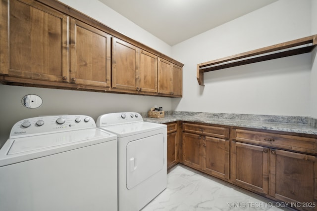 clothes washing area featuring separate washer and dryer and cabinets