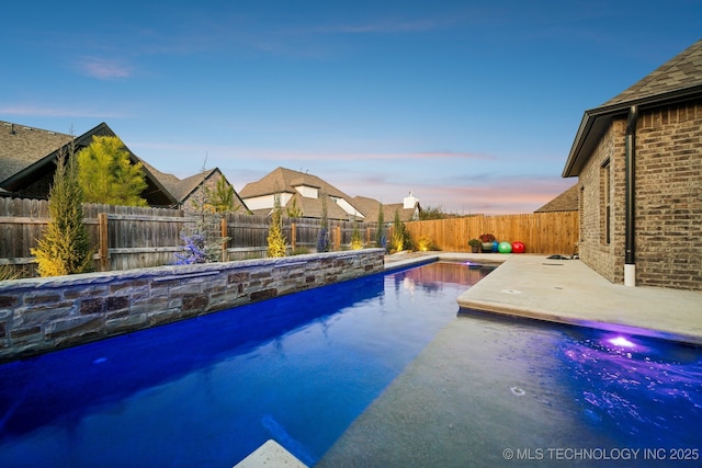 pool at dusk with a patio