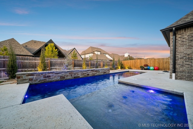 pool at dusk with a patio