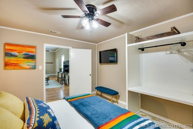 bedroom featuring a textured ceiling, ceiling fan, light hardwood / wood-style floors, and crown molding