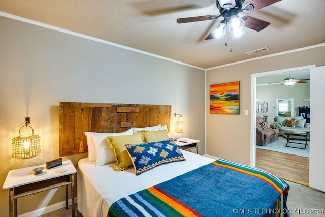 bedroom featuring hardwood / wood-style flooring, ceiling fan, and crown molding