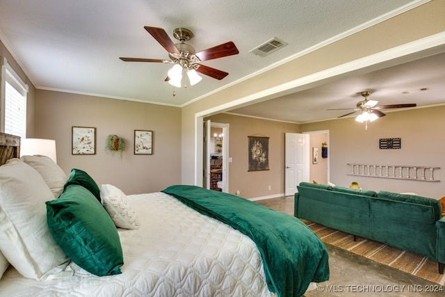 bedroom with a textured ceiling, a spacious closet, ceiling fan, and ornamental molding