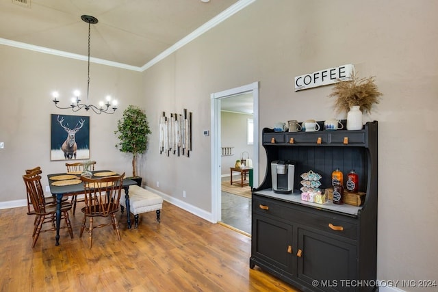 dining room featuring hardwood / wood-style flooring, ornamental molding, and an inviting chandelier