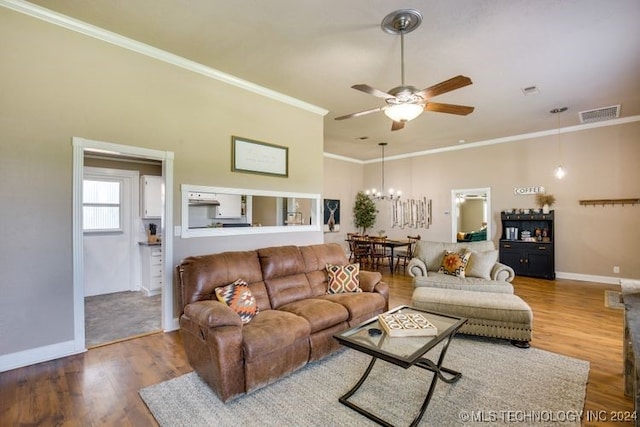 living room with hardwood / wood-style floors, ceiling fan with notable chandelier, and ornamental molding