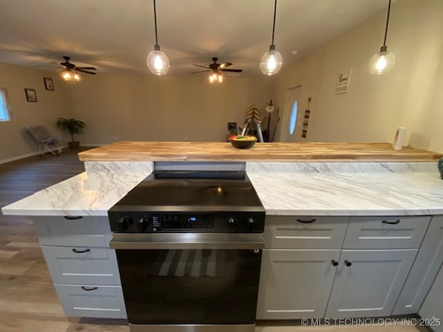 kitchen with electric range, wood finished floors, open floor plan, light stone countertops, and pendant lighting