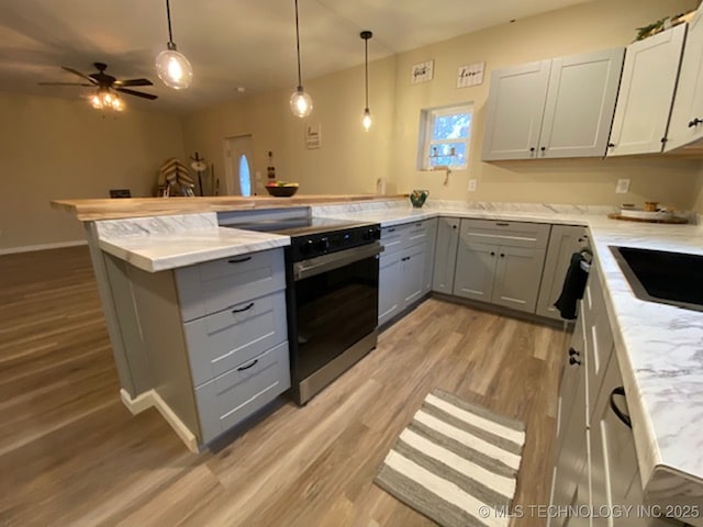 kitchen with ceiling fan, kitchen peninsula, gray cabinets, decorative light fixtures, and electric stove