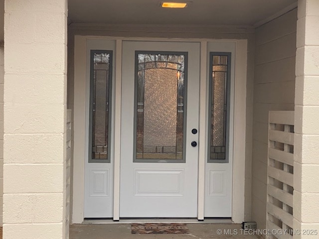 entrance to property featuring concrete block siding