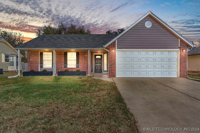 ranch-style home featuring a garage and a lawn