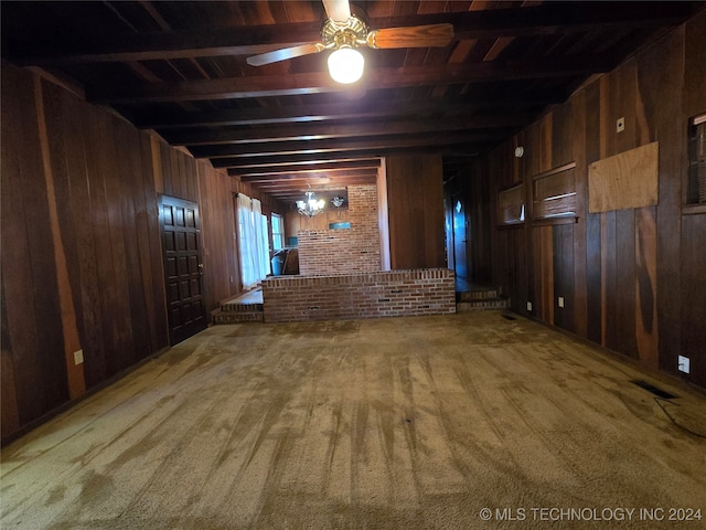 interior space with beamed ceiling, ceiling fan, and wood walls