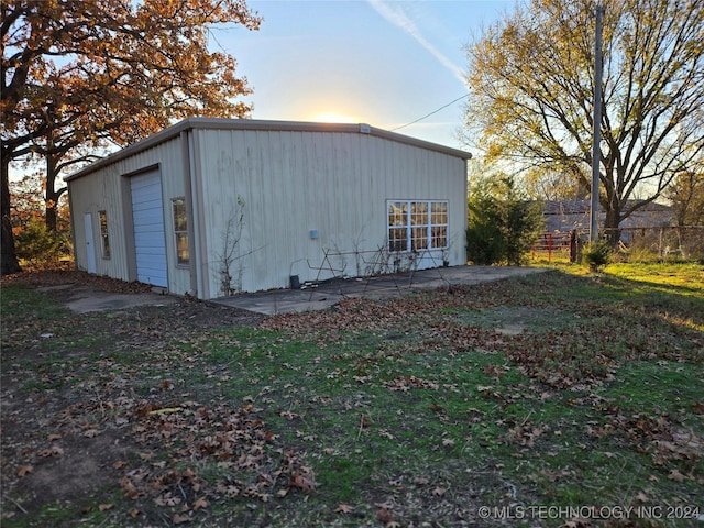 view of outdoor structure with a lawn and a garage