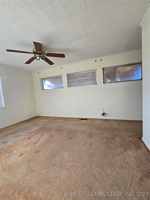 carpeted empty room featuring ceiling fan and a textured ceiling