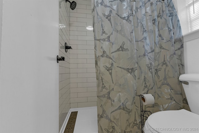 bathroom featuring curtained shower and toilet