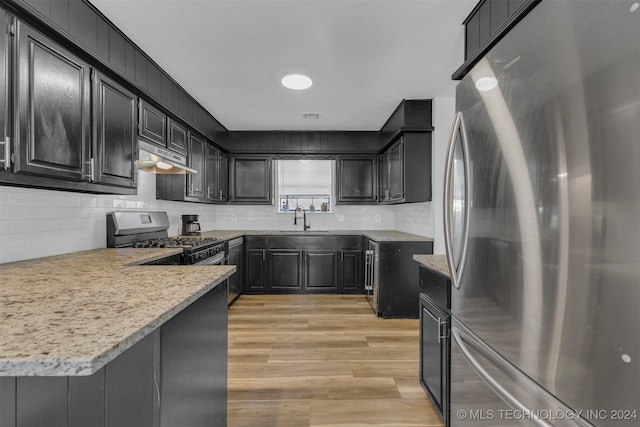 kitchen featuring tasteful backsplash, stainless steel appliances, and light hardwood / wood-style floors