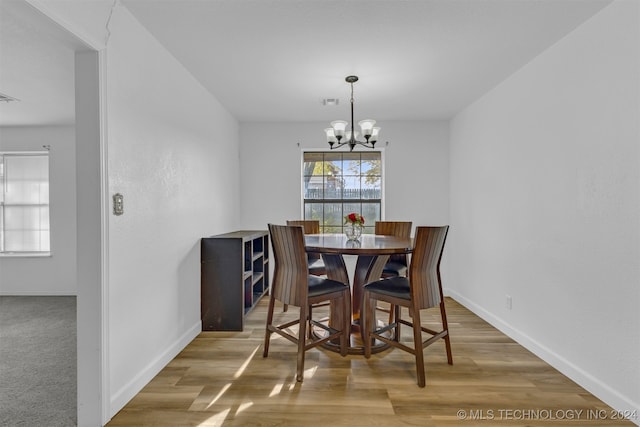 dining area featuring hardwood / wood-style flooring and a notable chandelier