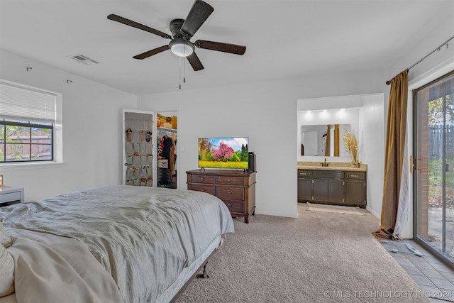 bedroom with access to exterior, light carpet, ensuite bathroom, ceiling fan, and a closet