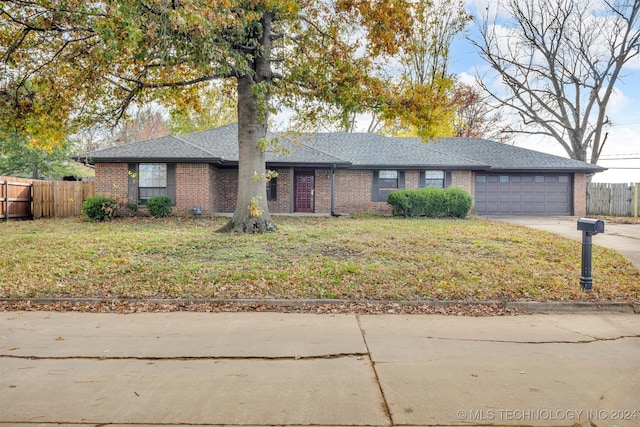 ranch-style home featuring a front lawn and a garage