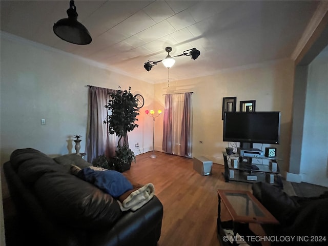 living room with wood-type flooring and ornamental molding