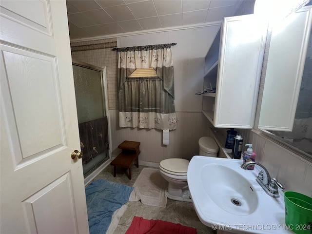 bathroom featuring toilet, crown molding, sink, and walk in shower