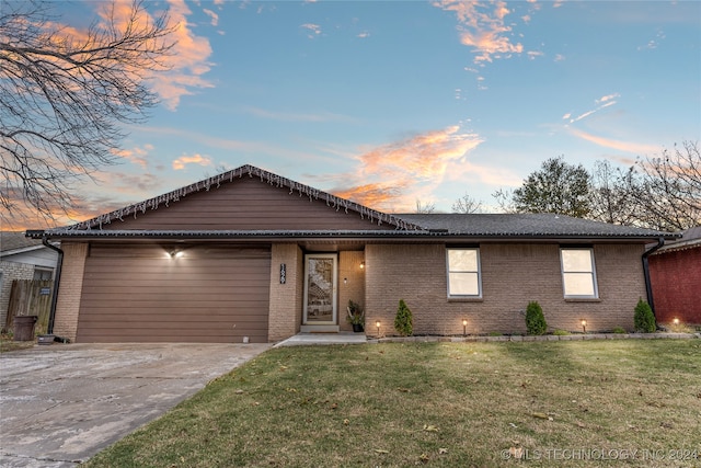 ranch-style house with a garage and a yard