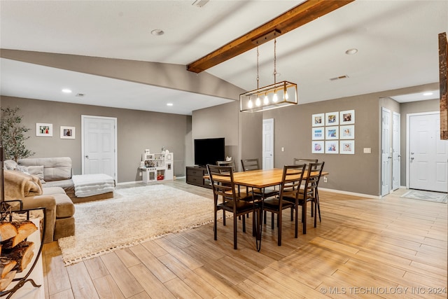 dining room with lofted ceiling with beams and light wood-type flooring