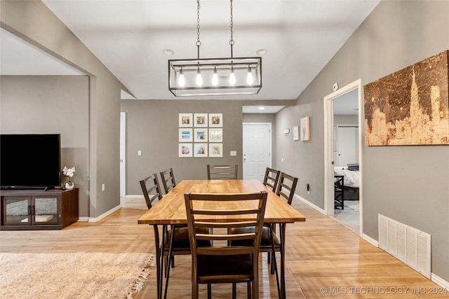 dining room featuring hardwood / wood-style floors and vaulted ceiling