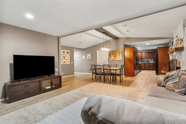 living room featuring lofted ceiling with beams, light wood-type flooring, and a chandelier