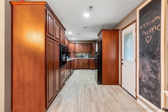 kitchen featuring light hardwood / wood-style flooring and black appliances