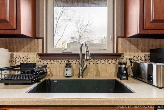 kitchen featuring backsplash, plenty of natural light, and sink