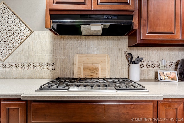 kitchen with backsplash, extractor fan, and stainless steel gas stovetop