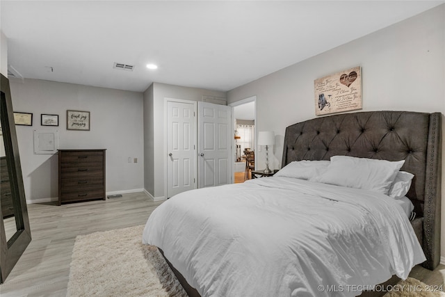 bedroom with light hardwood / wood-style floors and a closet