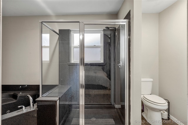 bathroom with toilet, a shower with door, and a healthy amount of sunlight