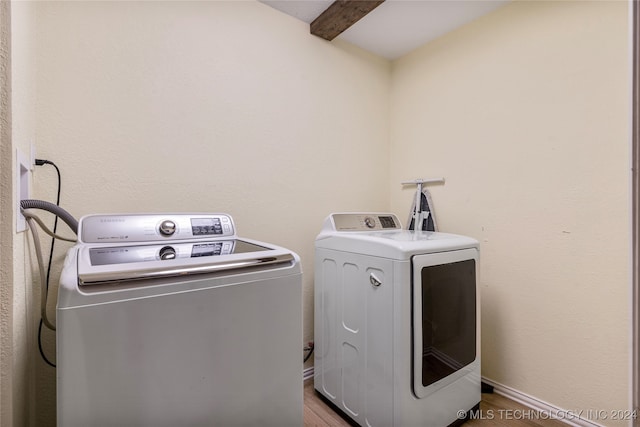 clothes washing area featuring washer and clothes dryer and wood-type flooring