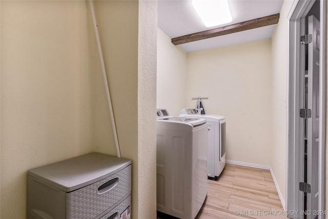 clothes washing area featuring washer and clothes dryer and light wood-type flooring