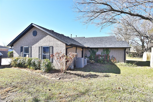 back of house featuring central AC unit and a lawn