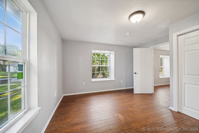 empty room featuring dark hardwood / wood-style flooring and a wealth of natural light