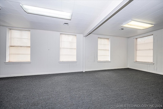 carpeted spare room featuring beamed ceiling