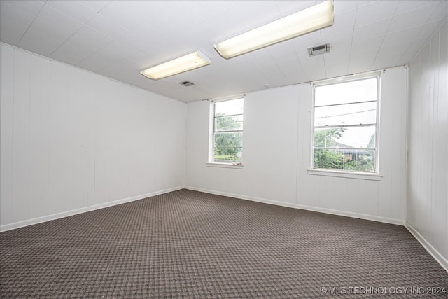 unfurnished room with dark colored carpet