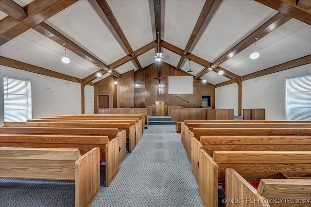 interior space featuring wood walls, vaulted ceiling with beams, and a healthy amount of sunlight