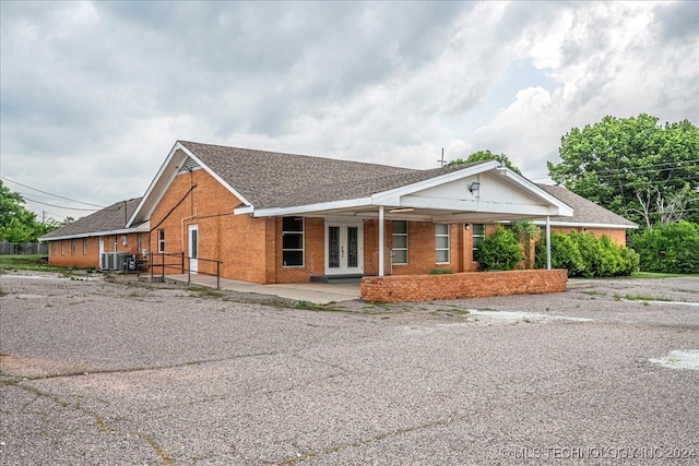 ranch-style house with french doors and central AC unit