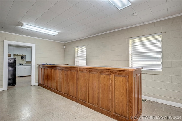 bar featuring black fridge and ornamental molding