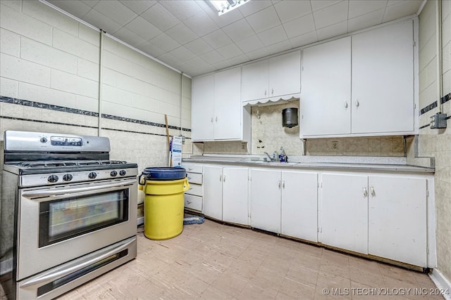 kitchen featuring sink, white cabinets, and stainless steel gas range